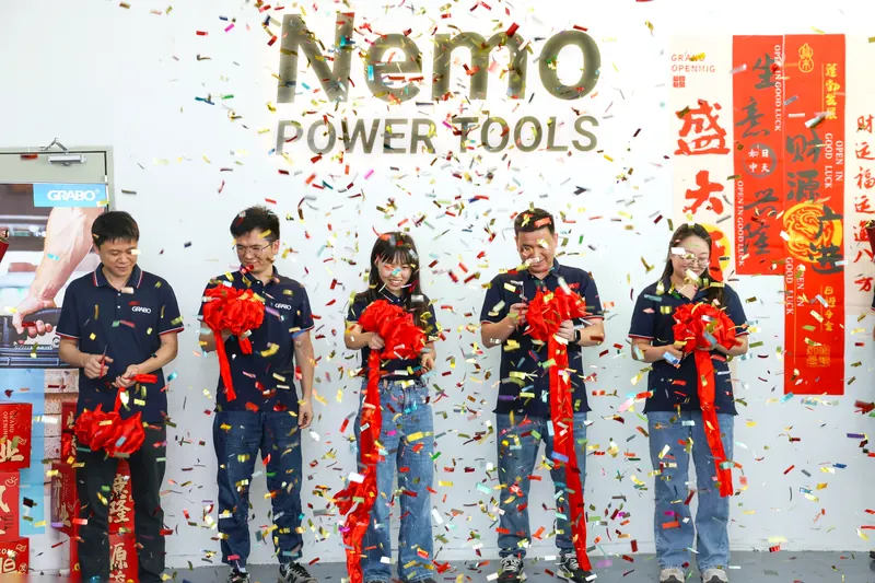 Ribbon cutting with confetti under the Nemo Power Tools sign